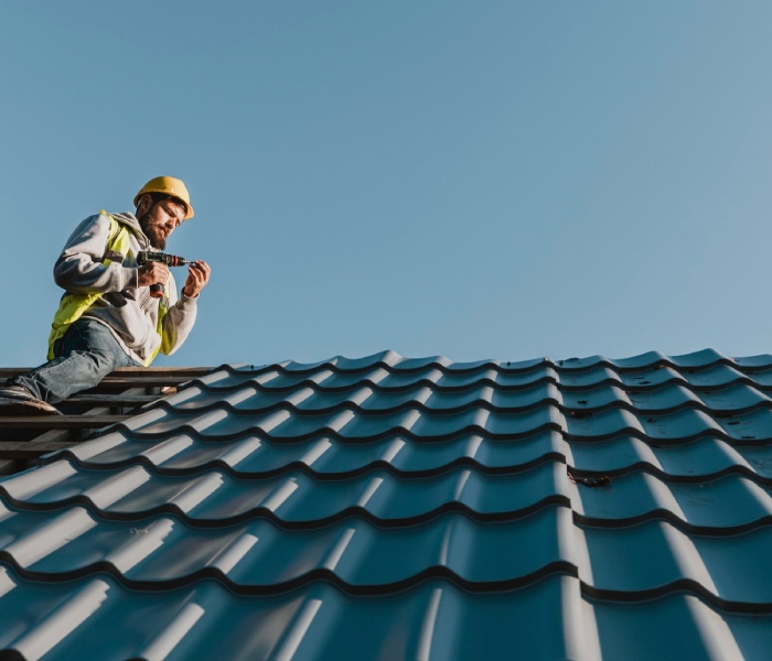 Couvreur installant une toiture en bac acier pour l’entreprise de couverture zinguerie Vabre Couverture